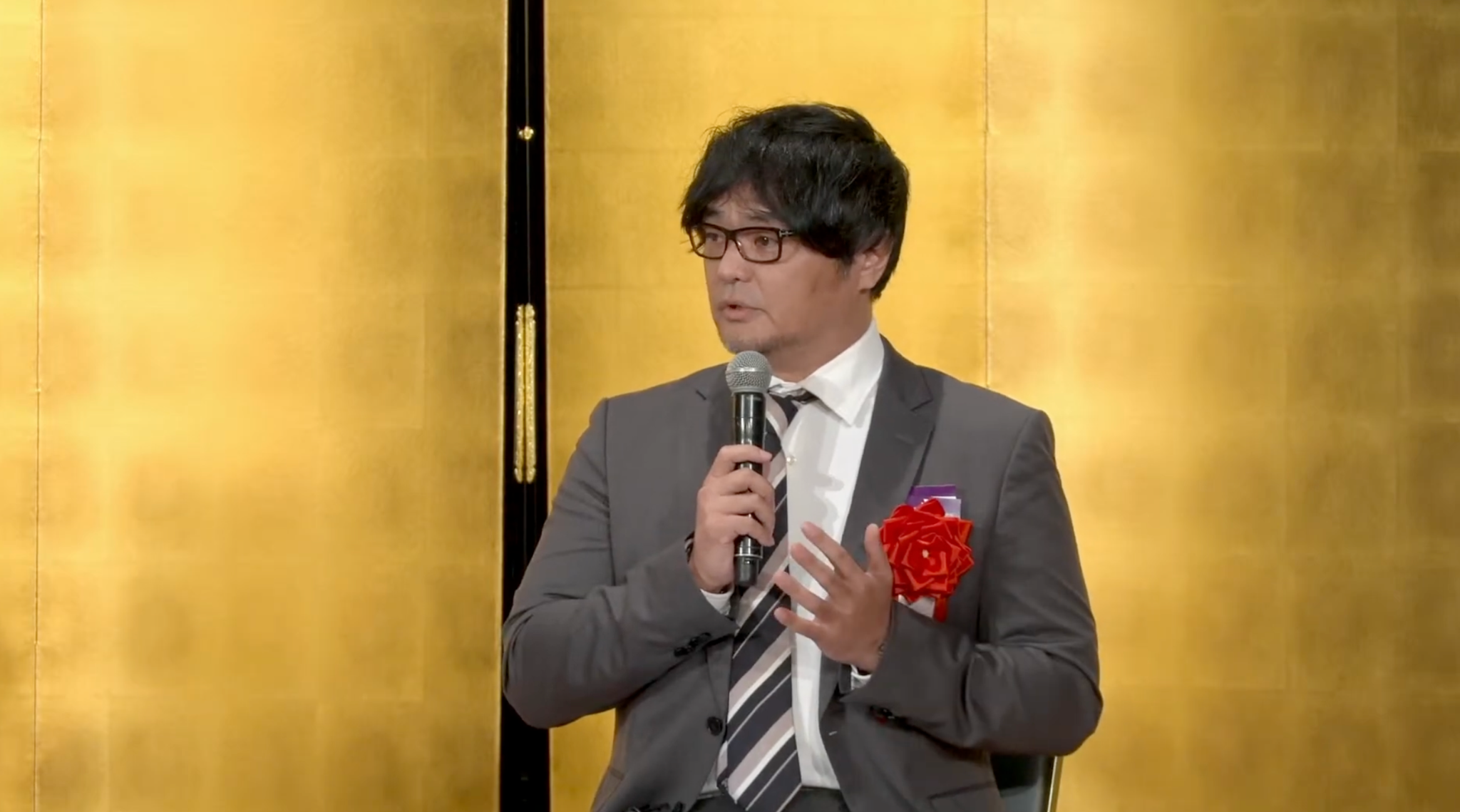 同志社大学・樹徳会100周年記念イベントでマイクを持って登壇する藤村雄志